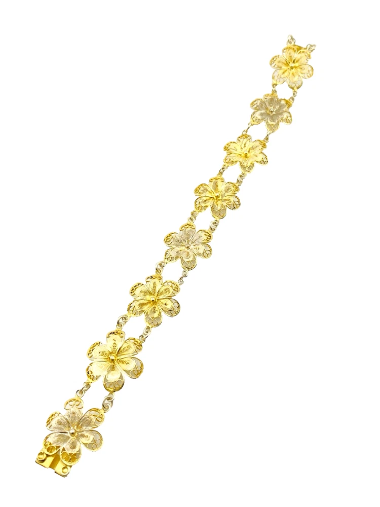 Pale gold-over-silver bracelet with eight six-petal filigree flowers, raised bead centers, and paired connecting links.