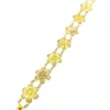 Pale gold-over-silver bracelet with eight six-petal filigree flowers, raised bead centers, and paired connecting links.