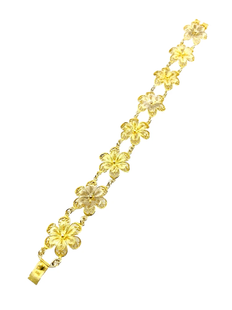Pale gold-over-silver bracelet with eight six-petal filigree flowers, raised bead centers, and paired connecting links.