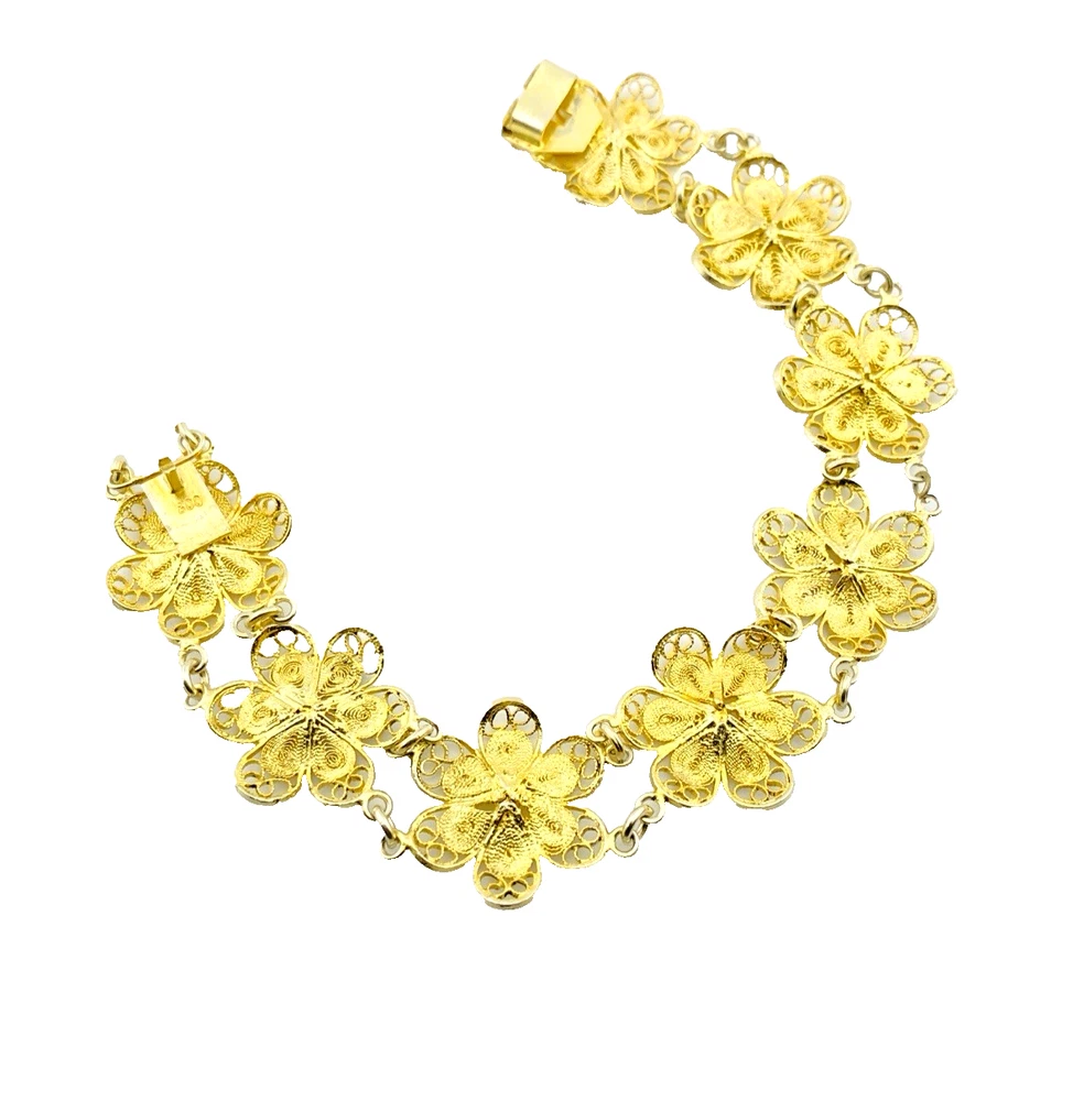 Pale gold-over-silver bracelet with eight six-petal filigree flowers, raised bead centers, and paired connecting links.