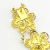 Pale gold-over-silver bracelet with eight six-petal filigree flowers, raised bead centers, and paired connecting links.