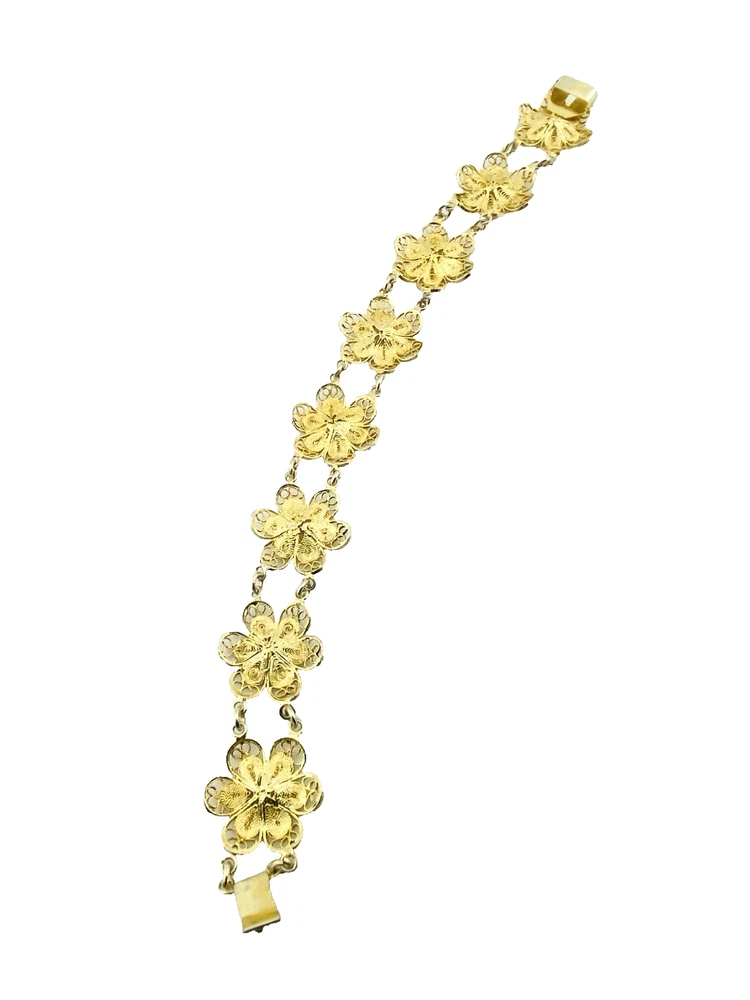 Pale gold-over-silver bracelet with eight six-petal filigree flowers, raised bead centers, and paired connecting links.