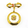 Gold-plated WWII sweetheart locket brooch with an eagle-and-shield emblem on mother of pearl, engraved border, and red, white, and blue enameled bow.