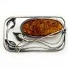 Circa 1990s sterling silver brooch with a large oval cognac amber cabochon and three calla lilies forming an open rectangular frame.