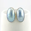 Great Falls Metal Works oval light blue mabé pearl earrings in narrow sterling silver bezels, shown upright from the front.