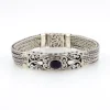 Multistrand silver bracelet with square woven chains, curved scrollwork panel, oval garnet and decorated box clasp