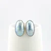 Great Falls Metal Works oval light blue mabé pearl earrings in narrow sterling silver bezels, shown upright from the front.