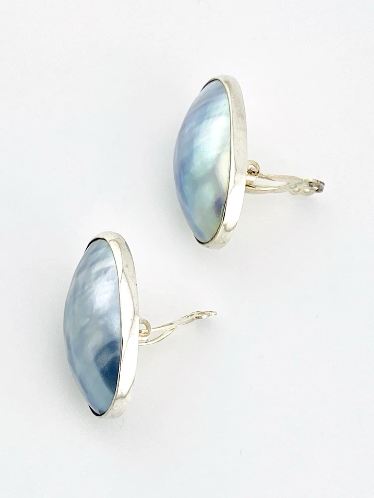 Great Falls Metal Works oval light blue mabé pearl earrings in narrow sterling silver bezels, shown upright from the front.