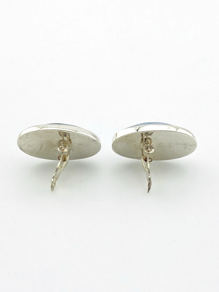 Great Falls Metal Works oval light blue mabé pearl earrings in narrow sterling silver bezels, shown upright from the front.