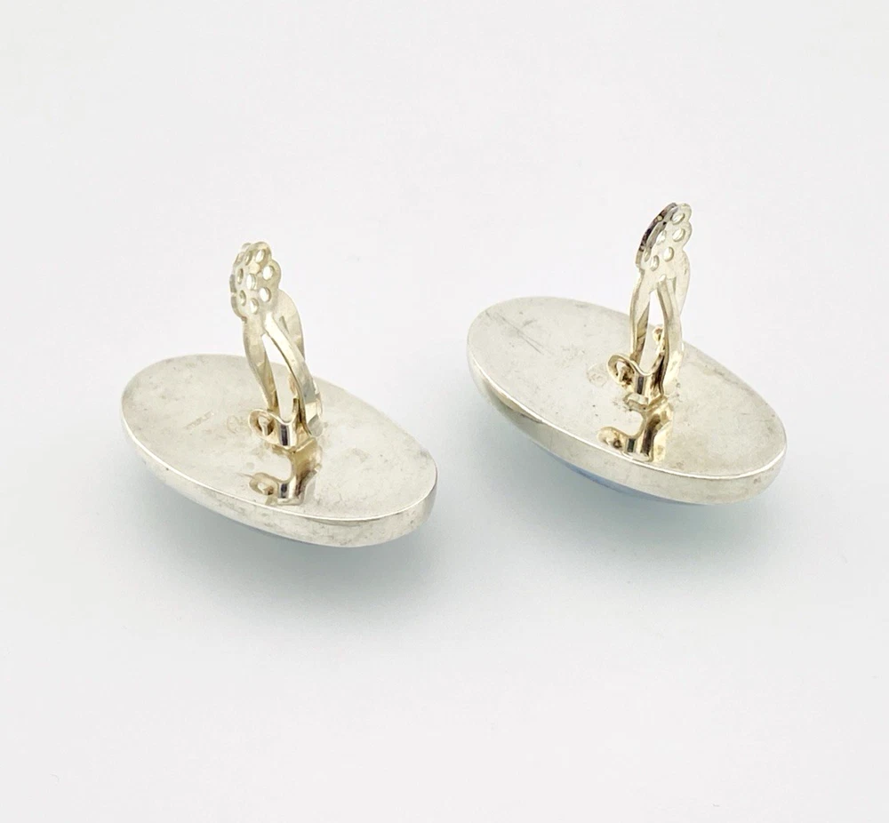 Great Falls Metal Works oval light blue mabé pearl earrings in narrow sterling silver bezels, shown upright from the front.