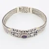 Multistrand silver bracelet with square woven chains, curved scrollwork panel, oval garnet and decorated box clasp