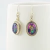 VIVAH oval mystic topaz drop earrings with purple, pink, green, and blue reflections, bordered by concentric sterling silver frames.