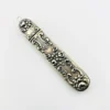 Vintage sterling silver needle case with raised cabbage roses, curling scrollwork, darkened recesses, and a suspension loop on the cap.