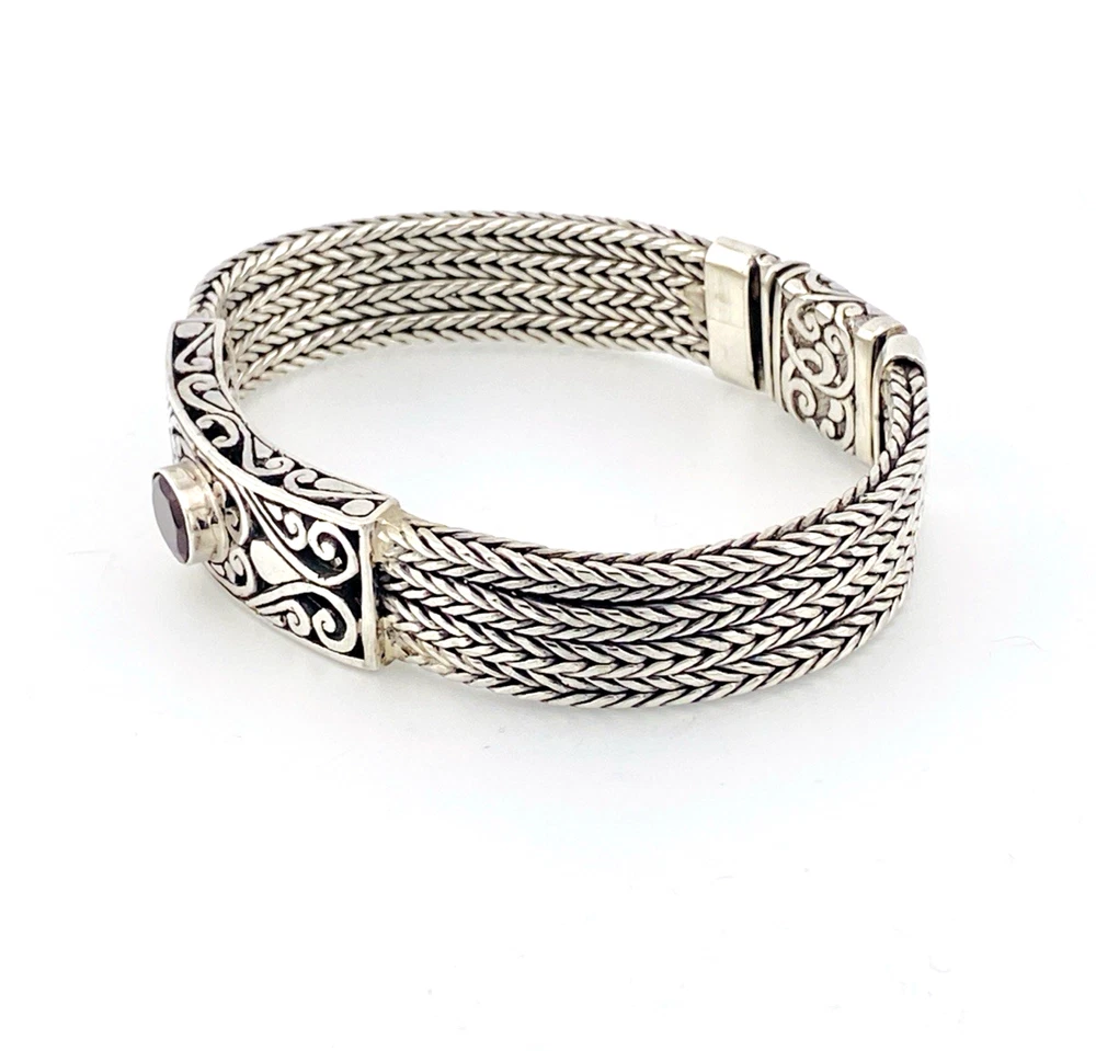 Multistrand silver bracelet with square woven chains, curved scrollwork panel, oval garnet and decorated box clasp