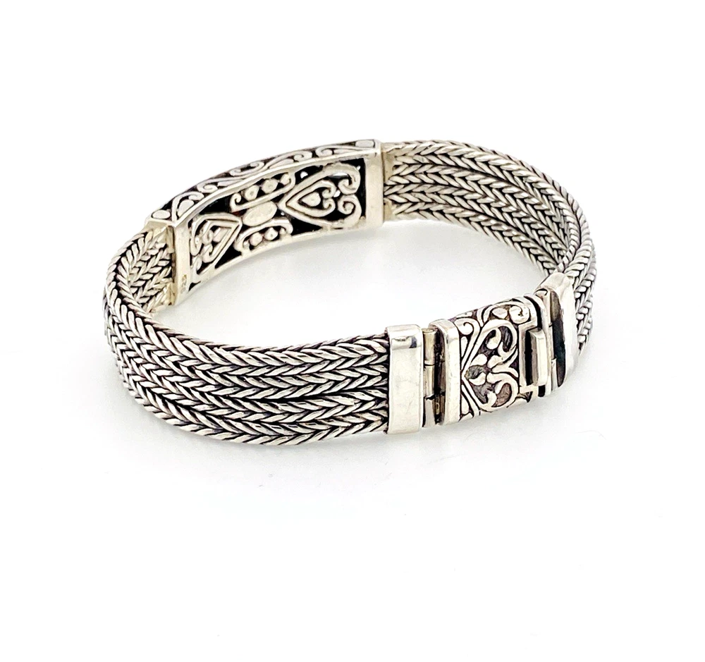 Multistrand silver bracelet with square woven chains, curved scrollwork panel, oval garnet and decorated box clasp