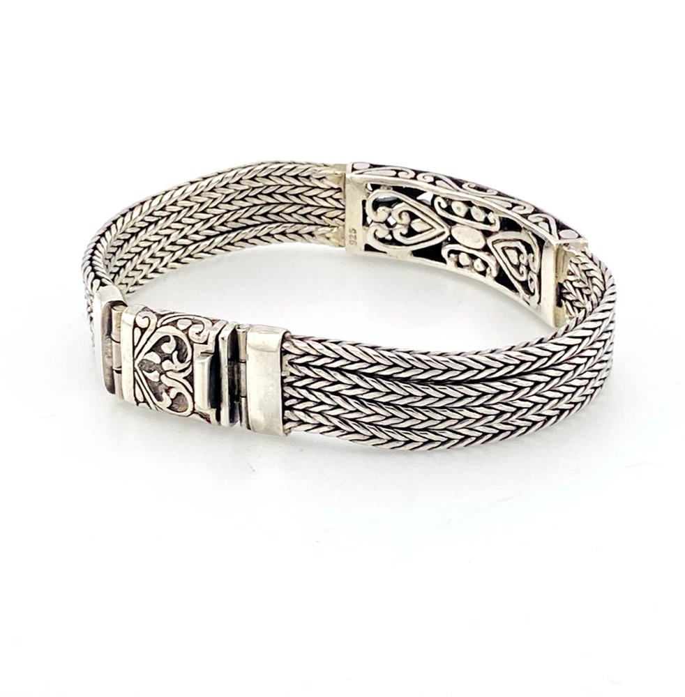 Multistrand silver bracelet with square woven chains, curved scrollwork panel, oval garnet and decorated box clasp