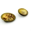 Two antique gold-tone rope-border brooches: a round faded portrait of a woman and an oval tintype portrait of a young child.