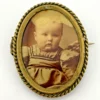 Two antique gold-tone rope-border brooches: a round faded portrait of a woman and an oval tintype portrait of a young child.