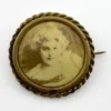 Two antique gold-tone rope-border brooches: a round faded portrait of a woman and an oval tintype portrait of a young child.