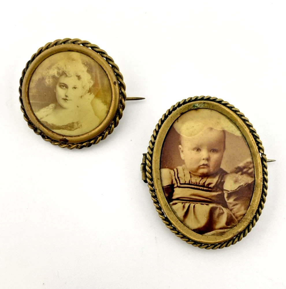Two antique gold-tone rope-border brooches: a round faded portrait of a woman and an oval tintype portrait of a young child.