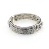 Multistrand silver bracelet with square woven chains, curved scrollwork panel, oval garnet and decorated box clasp