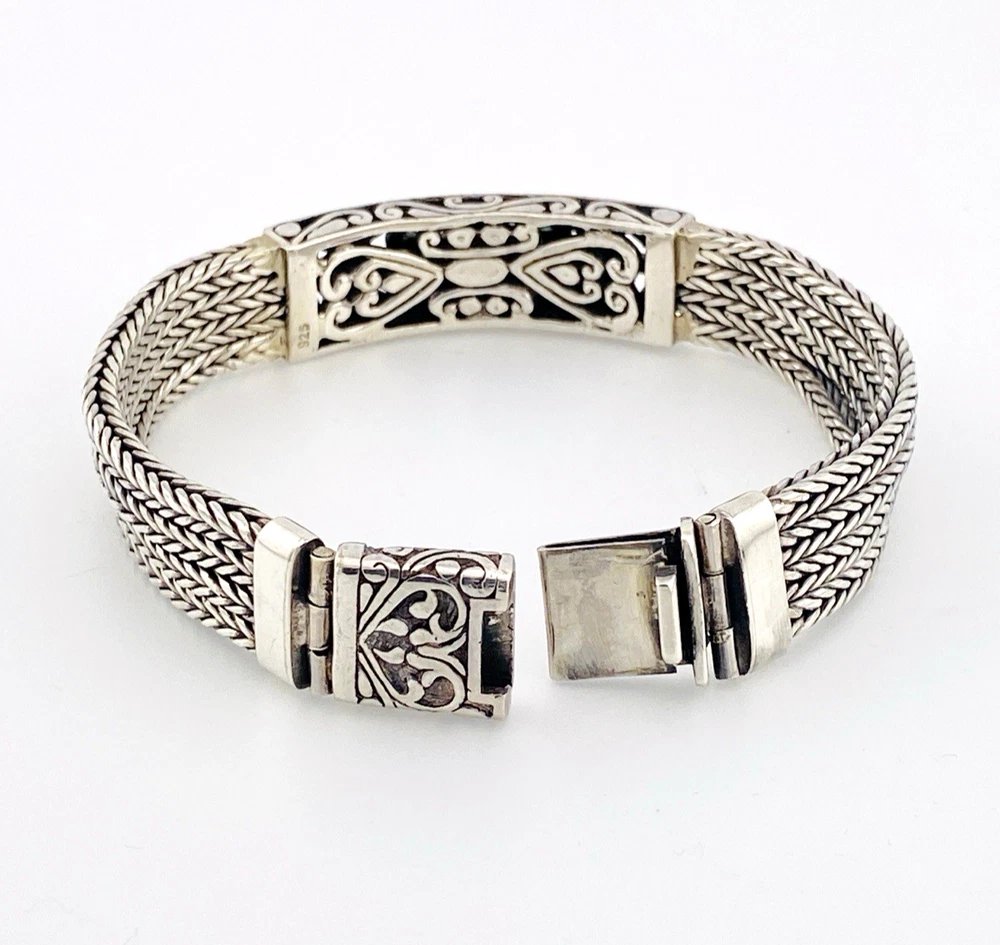Multistrand silver bracelet with square woven chains, curved scrollwork panel, oval garnet and decorated box clasp