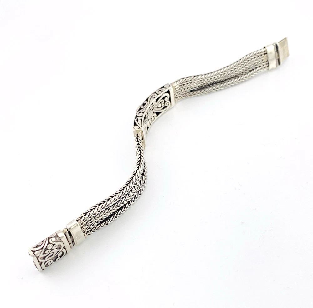 Multistrand silver bracelet with square woven chains, curved scrollwork panel, oval garnet and decorated box clasp