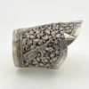 Wide peaked silver cuff with three crowned celestial dancers, openwork leafy scrolls and a rounded longevity medallion