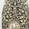 Wide peaked silver cuff with three crowned celestial dancers, openwork leafy scrolls and a rounded longevity medallion
