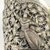 Wide peaked silver cuff with three crowned celestial dancers, openwork leafy scrolls and a rounded longevity medallion