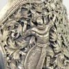 Wide peaked silver cuff with three crowned celestial dancers, openwork leafy scrolls and a rounded longevity medallion