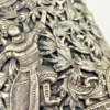Wide peaked silver cuff with three crowned celestial dancers, openwork leafy scrolls and a rounded longevity medallion