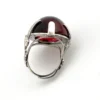 High-domed red glass cabochon ring with broad silver prongs, fleur-de-lis shoulders and an overlapping adjustable band